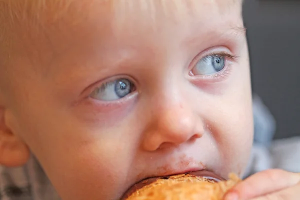 Хлопчик їсть круасани — стокове фото