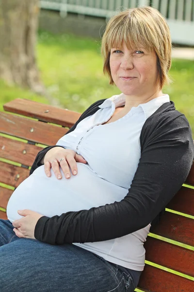 怀孕的女人是坐在板凳上 — 图库照片