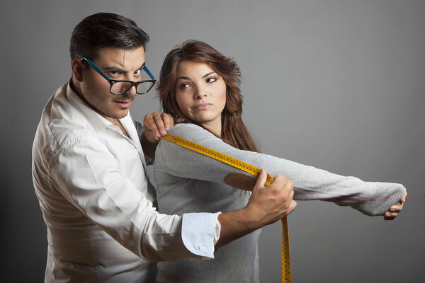 Портной принимает меры молодой женщины
