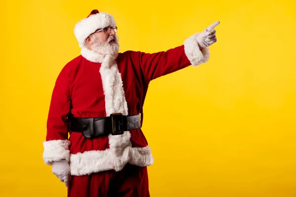 Noel Baba Sarı Arka Plandaki Reklam Panosunu Işaret Ediyor — Stok fotoğraf