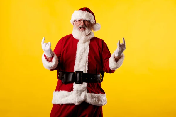 Санта Клаус Делает Рокерский Жест Жёлтом Фоне — стоковое фото