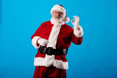 Noel Baba mavi arka planda iyi bir jest yapıyor