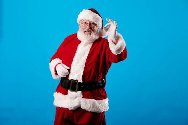 Noel Baba mavi arka planda iyi bir jest yapıyor