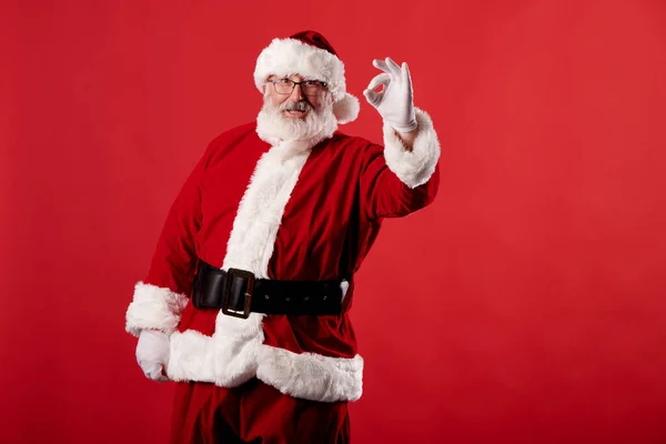 Noel Baba Kırmızı Arka Planda Iyi Bir Jest Yapıyor — Stok fotoğraf