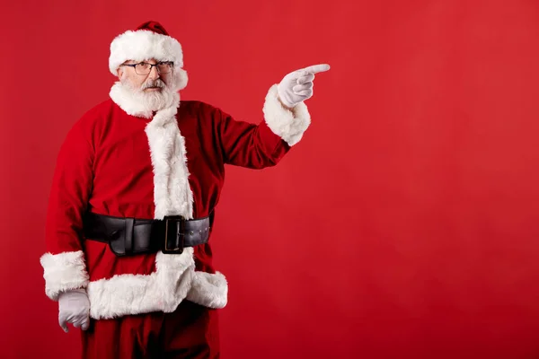 Noel Baba Kırmızı Arka Plandaki Reklam Panosunu Işaret Ediyor — Stok fotoğraf