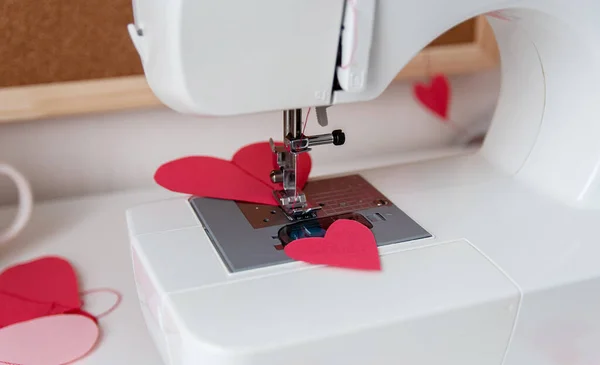 Швейная машинка и бумажные сердца. Процесс изготовления гирлянды. Сшить с любовью ко Дню святого Валентина. — стоковое фото