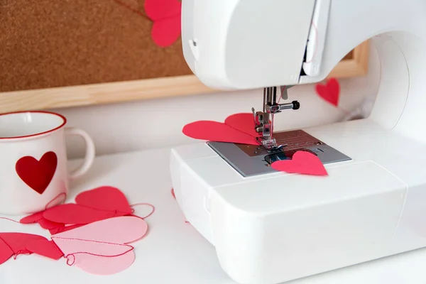 Швейная машинка и бумажные сердца. Процесс изготовления гирлянды. Сшить с любовью ко Дню святого Валентина. — стоковое фото