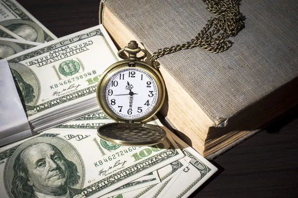 Still life image of pocket watch on bills and old book — Stock Photo, Image