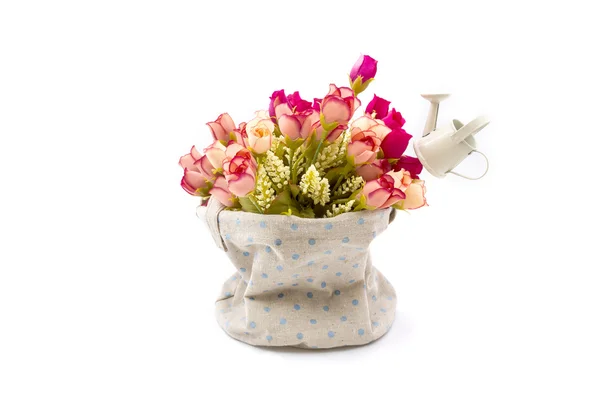 Roses and small watering pot in fabric vase on white — Stock Photo, Image