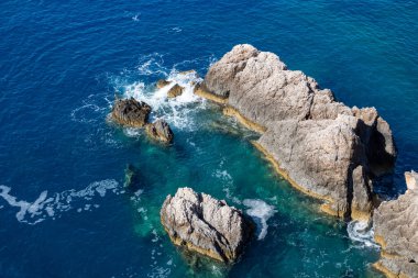 Mavi İyon denizinde sakin dalgalar kayalara vurur. Yunanistan 'ın Lefkada adasında yaz doğası. Üst hava görüntüsü