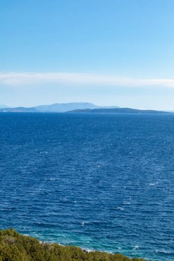 Yunan adaları açık mavi bir günde deniz kıyısında. Fırtınalı dalgalı su ve mavi gökyüzü. Lefkada adası, İyon deniz kıyısı, Yunanistan. Dikey