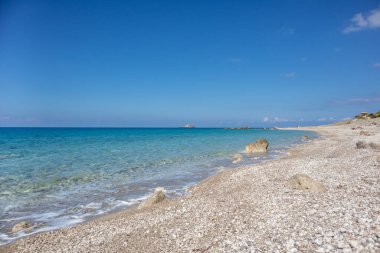Yunanistan 'ın Lefkada adasının açık deniz kıyısında kumsalda beyaz çakıl taşları ve kayalar. İyon Denizi 'ne yaz tatili