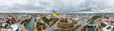 Bayrak direğinde bayrak direği, epik ağır bulutlu manzara, uçsuz bucaksız sonbahar nehri Lopan seti üzerinde şehir panoraması, Kutsal Annunciation Katedrali, Ukrayna 'nın Kharkiv kentinde merkez caddeler.