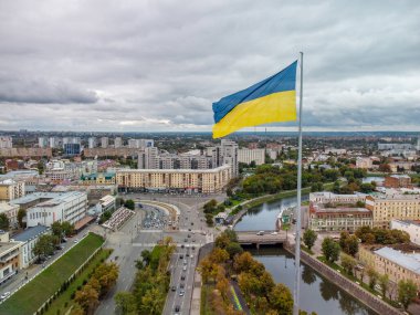 Ukrayna bayrağı, Ukrayna, Ukrayna 'nın başkenti Kharkiv' deki Skver Strilka, Pavlivska Meydanı, Lopan ırmağının kenarındaki merkez caddelerde sonbahar şehri panoramik manzarası.