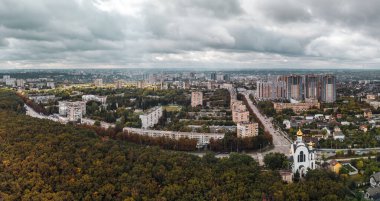 Dramatik bulutlu şehir manzarası manzarası. Kharkiv şehri Pavlovo Pole bölgesi, Nauky Caddesi manzaralı, kilise ve sonbahar ormanlarından kalma çok katlı binalar.