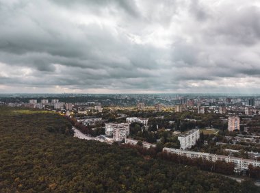 Dramatik bulutlu şehir manzarası. Kharkiv şehri Pavlovo Pole bölgesi, Derevianka caddesinde sonbahardan kalma karanlık orman binaları var.