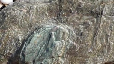 Deniz suyundaki yeşil büyük mermer taş dalga dalga dalga yaklaşıyor. Yunanistan 'daki temiz Ege deniz suyunda güneş ışığı ve deniz yosunu olan su altı kayaları. Vahşi deniz doğası