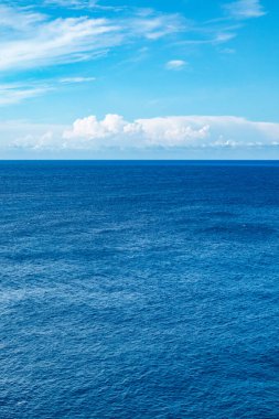 Lefkada Yunanistan adasındaki mavi İyon deniz manzarası. Uzak adaların üzerinde alçak bulutlarla aydınlık bir gün. Dikey deniz arka planı