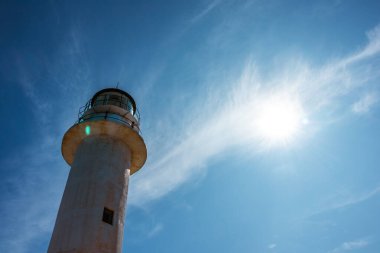 Lefkada adasındaki deniz feneri beyaz binasında açık mavi bir günde Yunanistan 'da güneş parlıyor. İyon Denizi üzerinde manzaralı seyahat