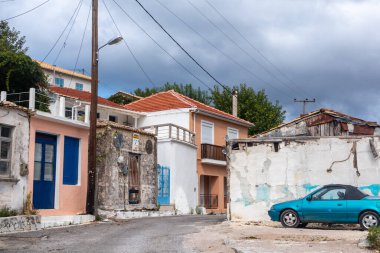 Yunanistan 'ın Lefkada adasındaki uzak geleneksel Yunan köyü sokakları. Küçük renkli evleri ve ağır kara bulutları olan bir arabası olan yerel bir atmosferi vardı. Yazın Avrupa seyahati