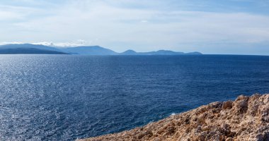 Uzak adalar geniş panorama arka planına sahip mavi canlı İyon deniz manzaralı Rocky dik uçurum. Yunanistan 'ın Lefkada adasında yaz doğası