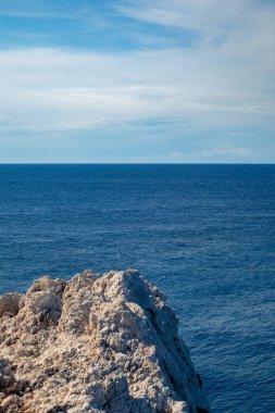 Mavi, canlı, İyon deniz manzaralı dik zeminde kayalık bir uçurum. Yunanistan 'ın Lefkada adasında yaz doğası
