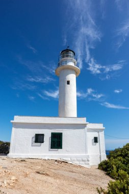 Yunanistan 'da açık mavi bir günde İyon deniz feneri beyaz binası. Manzaralı seyahat yeri. Lefkada adası. Dikey