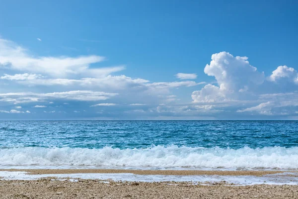 Mavi fırtına dalgaları ve beyaz köpükle sahili. Yunanistan 'ın Lefkada adasının kıyısındaki destansı bulutlar. İyon Denizi 'ne yaz tatili