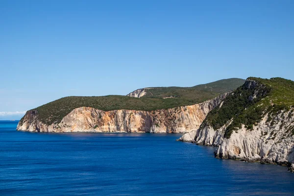 鮮やかな青い海と険しい岩の崖 ギリシャの明るい晴れた日に日当たりの良い海の海岸 風光明媚な旅行先 イオニア海沿岸のレフカダ島 — ストック写真