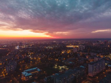 Kharkiv şehrinde gün batımı turuncu renkli canlı manzara, Pavlove direği. Konut semtinin sokaklarında gece lambaları ve manzaralı bulutlu gökyüzü. Moody aydınlatılmış şehir manzarası çatısı