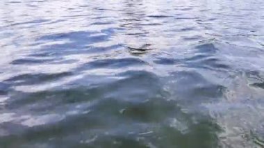 Mavi su derin dalgalar, bulutların vahşi gölü yansıtmasıyla kapanır. Doğanın güzelliği. Tekneyle açılmak. Görüntüleri döndür