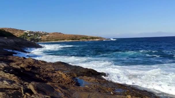 白色的暴风雨海浪冲击着岸上的岩石与蓝色生动的水 希腊雅典附近的海岸 夏季自然假期前往爱琴海 — 图库视频影像