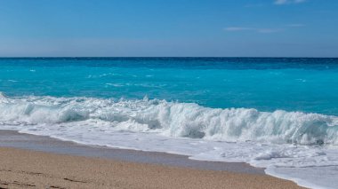 Mavi gökyüzü ile Yunan adasının kıyısında mavi dalgalar. Yunanistan 'da kumsal. Yaz doğası İyon Denizi 'ne seyahat