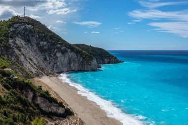 Yunanistan 'ın Lefkada adasının kıyısında, gök mavisi renkli, güneşli dalgalı Mylos kumlu plajı. İyon Denizi 'ne yaz tatili