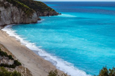 Yunanistan 'ın Lefkada adasında, Mylos kumlu sahilinde, gök mavisi, canlı, fırtınalı dalgalarla dolu bir hava manzarası. İyon Denizi 'ne yaz tatili