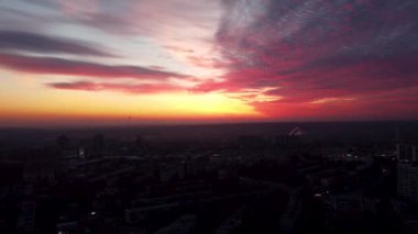 Gökyüzü destansı güneşli, canlı günbatımının üzerinde uçuyor. Hava Avrupa şehir merkezi, yerleşim bölgesi caddeleri akşam ışığında