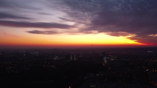壮大な雲と空中カラフルな夕日の街の景色 ハリコフ市内中心部の上を飛ぶパヴラブ ポール 夜のライトで車や建物のある住宅地の通り — ストック動画