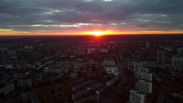 空中の街並み カラフルな夕日が壮大な雲の中で左側の景色に飛んでいます ハリコフ市内中心部 パヴラブポール住宅街や夜の光の中で建物 — ストック動画