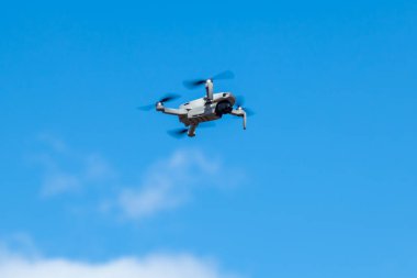 Kharkiv, Ukrayna - 6 Mart 2021: Dji Maviç Mini 2 İHA, güneşli mavi gün ışığında uçuyor. Bulutlu parlak gökyüzünde süzülen yeni kuadkopter aygıtı