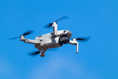 Kharkiv, Ukrayna - 6 Mart 2021: Dji Maviç Mini 2 İHA, güneşli gün ışığında uçuyor. Bulanık mavi gökyüzü arka planında gezinen yeni kuadkopter aygıtı