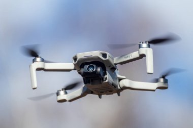 Kharkiv, Ukrayna - 6 Mart 2021: Dji Mavic Mini 2 insansız hava aracı kamera filtresi açık, güneşli mavi gün ışığında uçuyor. Bulanık bulutlu gökyüzü arkaplanında gezinen yeni dörtlü helikopter aygıtı