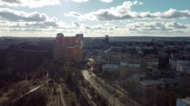 Kharkiv şehrinin solundaki ağaçtan sağa, Pavlovo Pole bölgesinde, güneşli bir bahar gününde manzaralı bulutlu gökyüzü olan çok katlı çok katlı binalar.