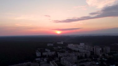 Hava manzaralı Kharkiv şehri Pavlove Pole yerleşim bölgesi. Karanlık orman, çok katlı evler ve bulutlarda kızıl güneş olan gün doğumu gökyüzü.