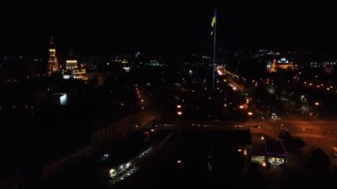 Ukrayna bayrağı aydınlatılmış gece nehir seti şehir manzarası, Lopan nehri üzerinde Skver Strilka ve Ukrayna 'nın Harkiv kentindeki Dormition Katedrali.