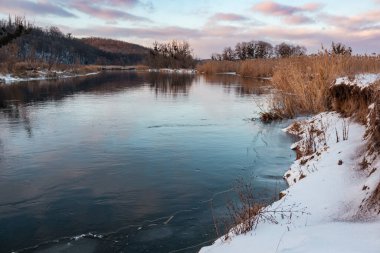 Soğuk nehir manzaralı soğuk nehir manzarası ayna suyunda yansıması olan renkli bulutlar ve kıyıda kuru sazlıklar. Siverskyi Donets Nehri üzerindeki Zmiyevsky bölgesi Ukrayna 'da karla kaplı