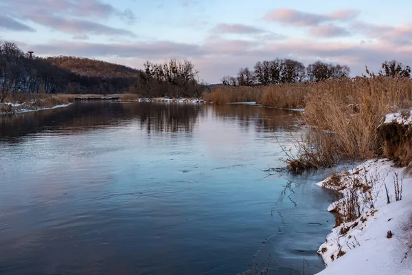 Soğuk nehir manzaralı soğuk nehir manzarası ayna suyunda yansıması olan mor bulutlar ve kıyıda kuru sazlıklar. Siverskyi Donets Nehri Ukrayna 'da karla kaplı.