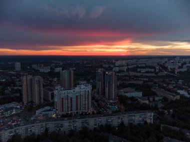 Vibrant sunset aerial view in city modern residential multistory district. 23 serpnia, Pavlovo Pole, Kharkiv, Ukraine. Fly at dusk, evening cloudscape and summer streets