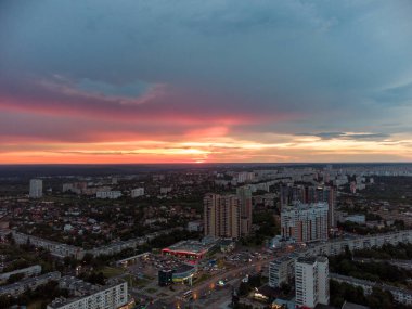 Epic vibrant sunset aerial view in city, residential district. 23 serpnia Pavlovo Pole Kharkiv, Ukraine. Fly with majestic evening cloudscape and city lights