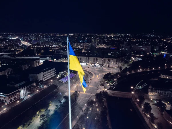 乌克兰国旗在漆黑的夜景中飘扬 乌克兰哈尔科夫市中心Skver Strilka附近灯火通明的Pavlivska广场的空中景观 — 图库照片