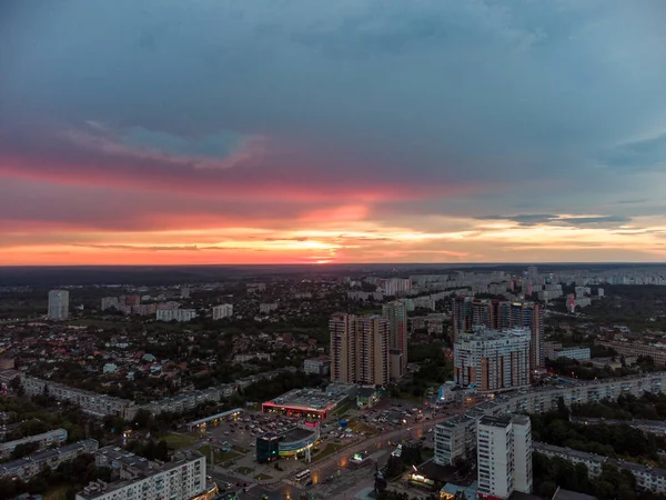 Epic vibrant sunset aerial view in city, residential district. 23 serpnia Pavlovo Pole Kharkiv, Ukraine. Fly with majestic evening cloudscape and city lights
